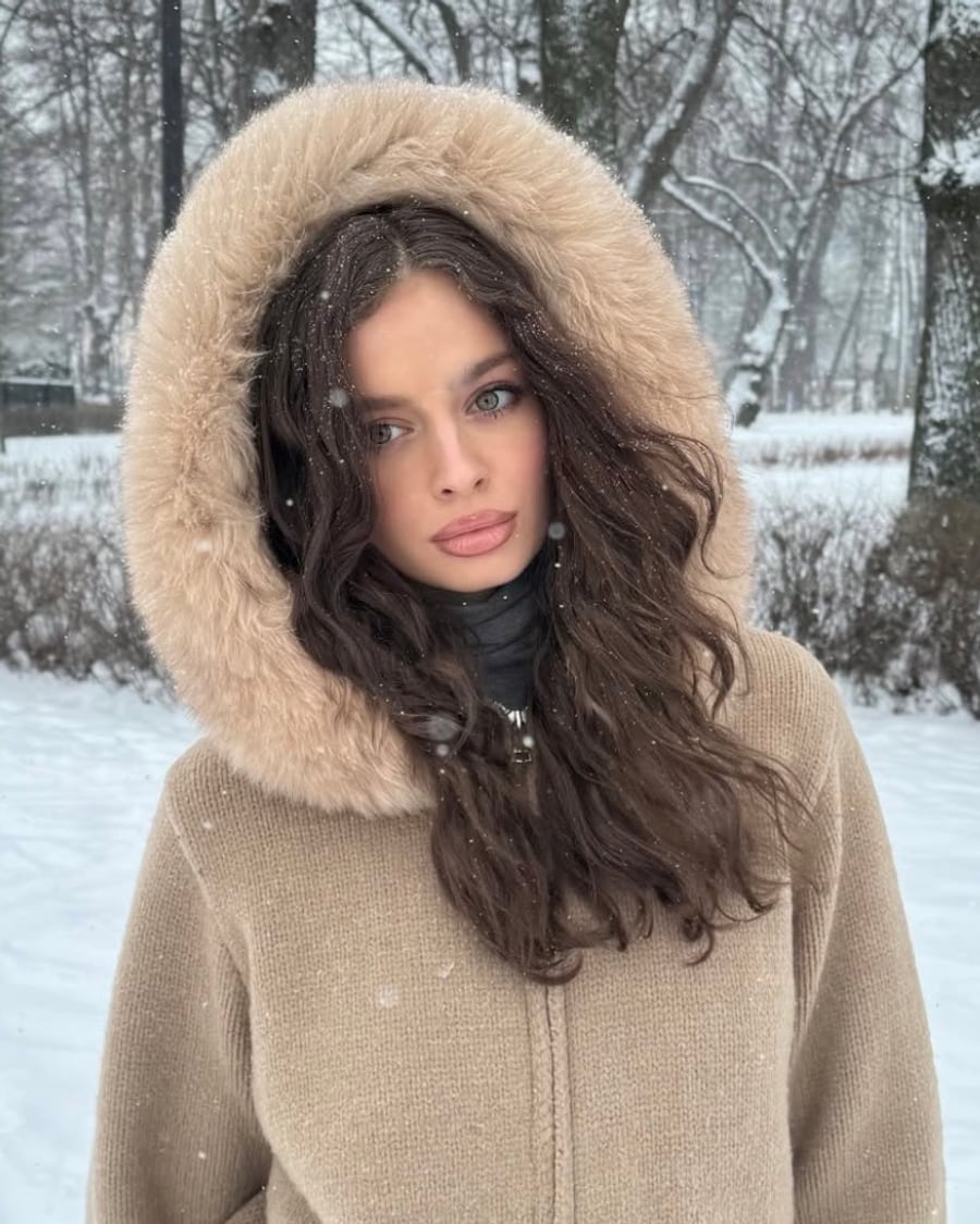 Veste à capuche beige portée sous la neige, capuche bordée de fausse fourrure